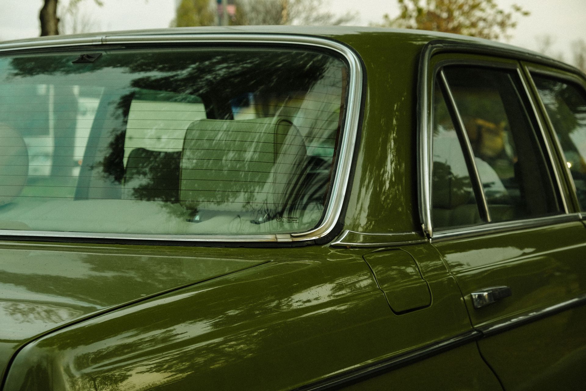 Close-up of a vintage green car captured from the back view, showcasing its classic design.