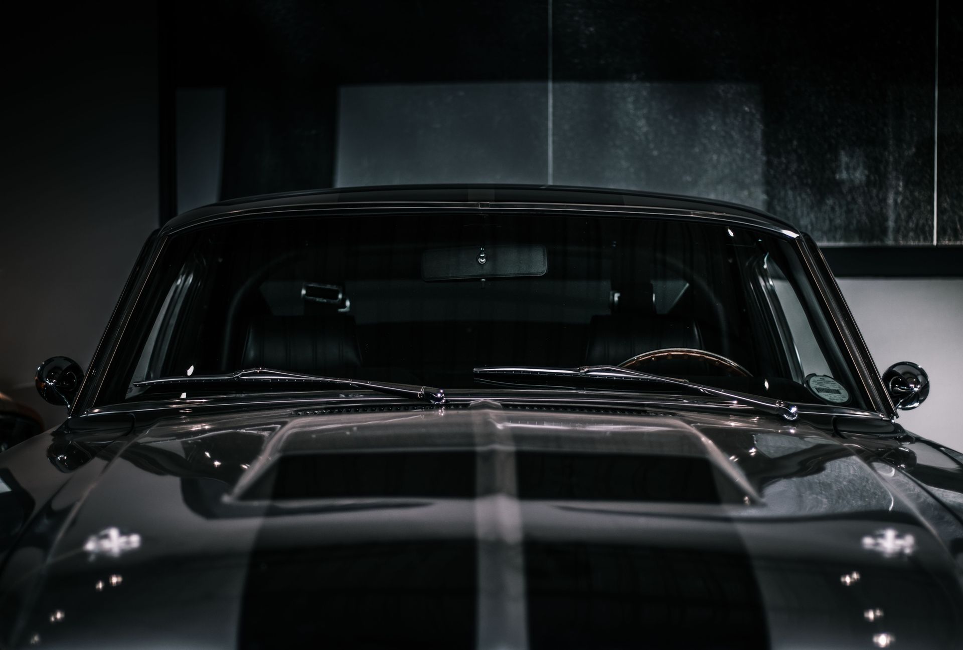 Close-up photo of a vintage muscle car parked in a garage showing detailed front view.